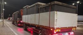 Samochód ciężarowy z przyczepą i przewożonymi pięcioma szambami betonowymi z pokrywami stoi w punkcie kontrolnym Inspekcji Transportu Drogowego.