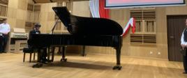 Na scenie młody pianista przy fortepianie.
