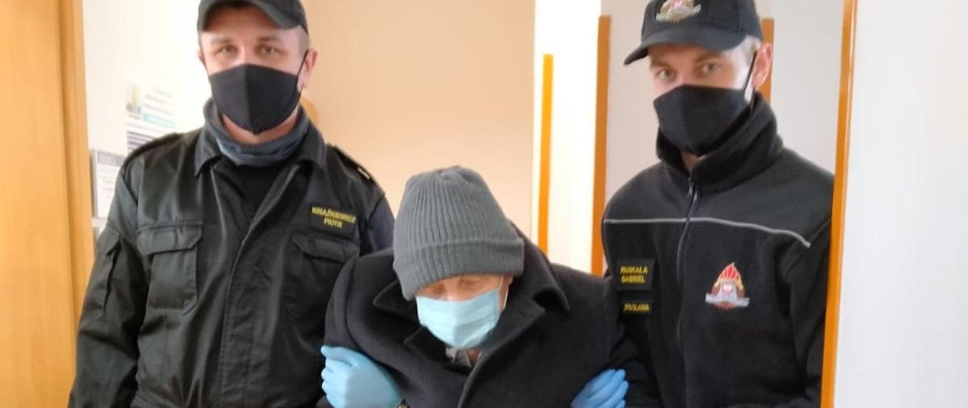 Strażacy Państwowej Straży Pożarnej pomagający w transporcie osoby do szczepienia