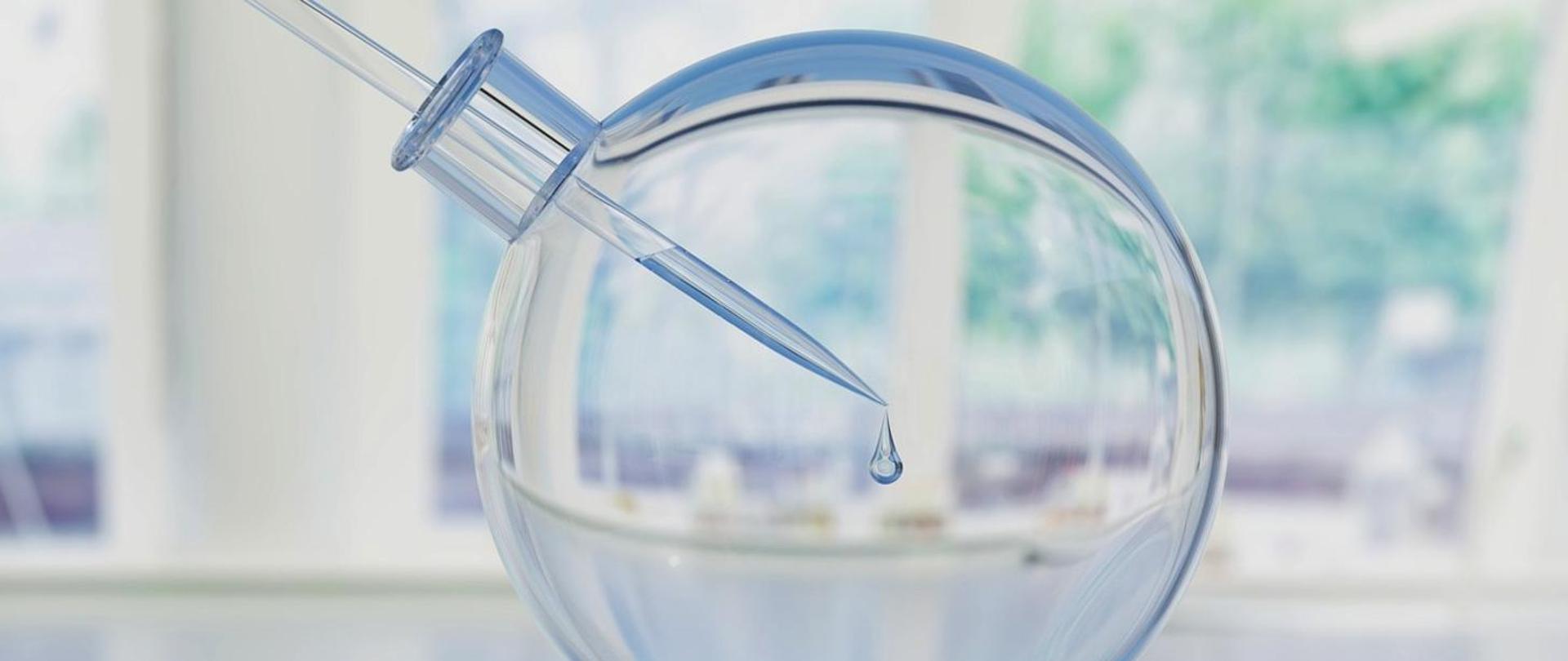 Szkło laboratoryjne z pipeta w środku 