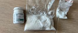 narkotyki - pojemnik plastikowy i dwie torebki foliowe z białym proszkiem