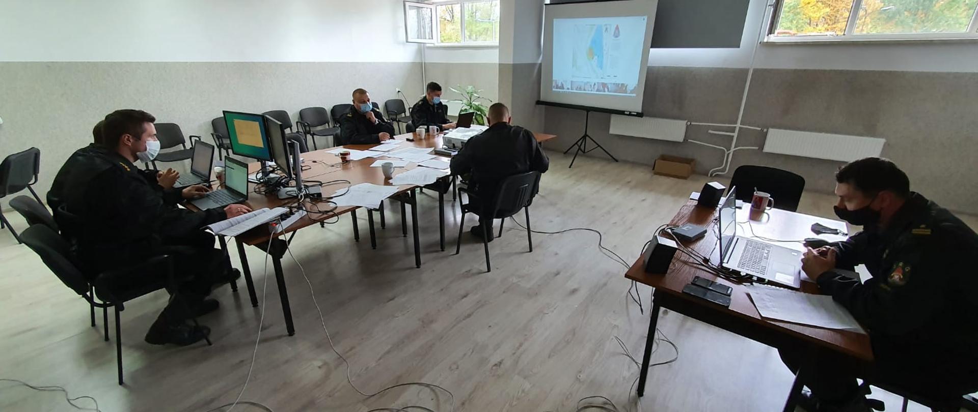 funkcjonariusze Komendy Powiatowej PSP w Cieszynie w sali sztabowej siedzący przed komputerami podczas ćwiczeń sztabowych
