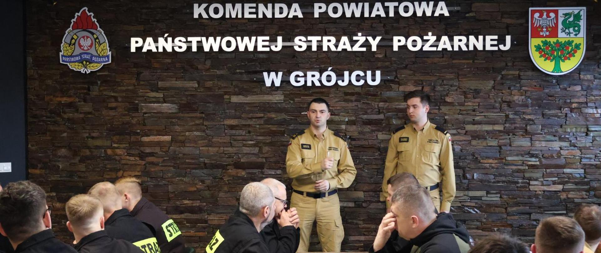 Na zdjęciu p.o. Zastępcy Komendanta Powiatowego PSP w Grójcu mł. bryg. Grzegorz Michalski, prowadzący pierwsze zajęcia st.str. Wojciech Dominiak i strażacy ochotnicy w sali wykładowej Komendy Powiatowej. 