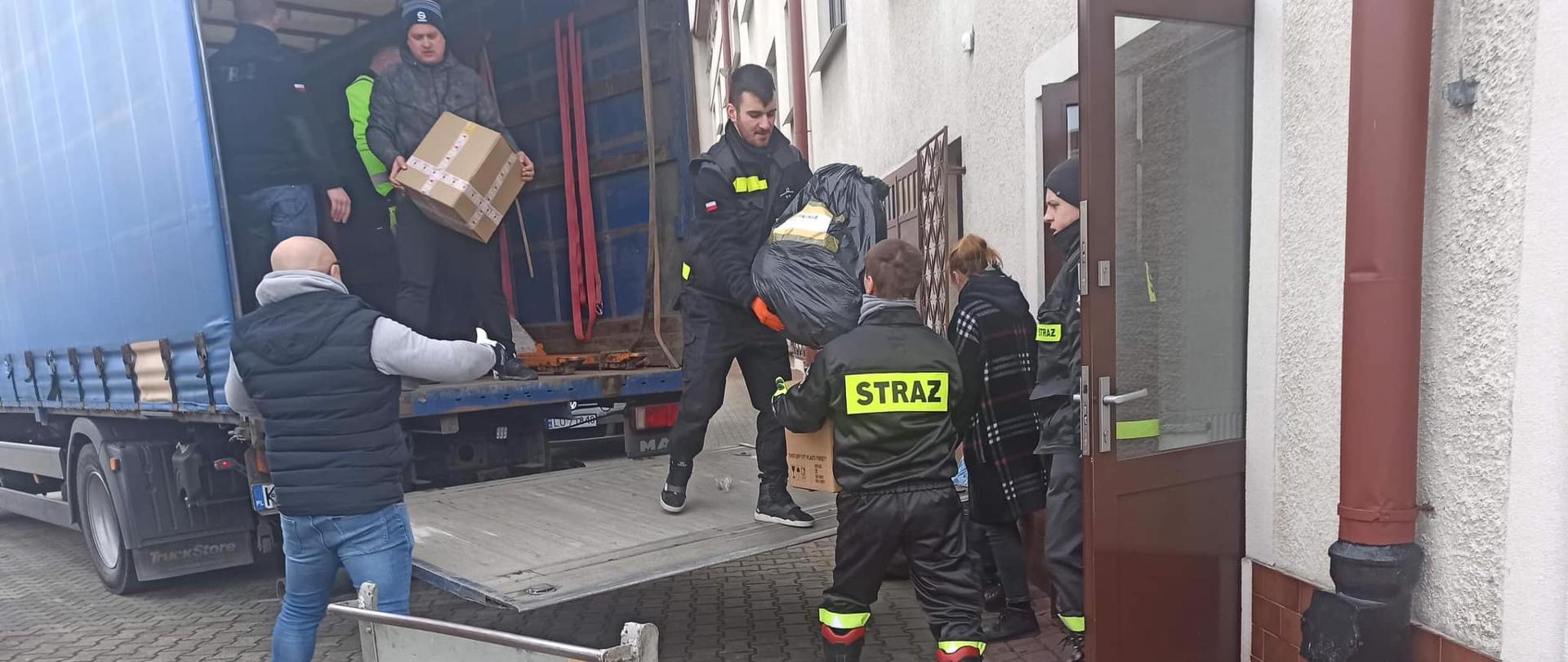 Strażacy przenoszą materiały w ramach pomocy dla uchodźców z Ukrainy