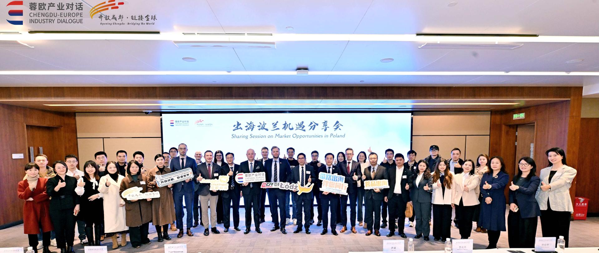 Uczestnicy forum inwestycyjnego w Chengdu pozują do wspólnego zdjęcia na scenie po zakończeniu wydarzenia.