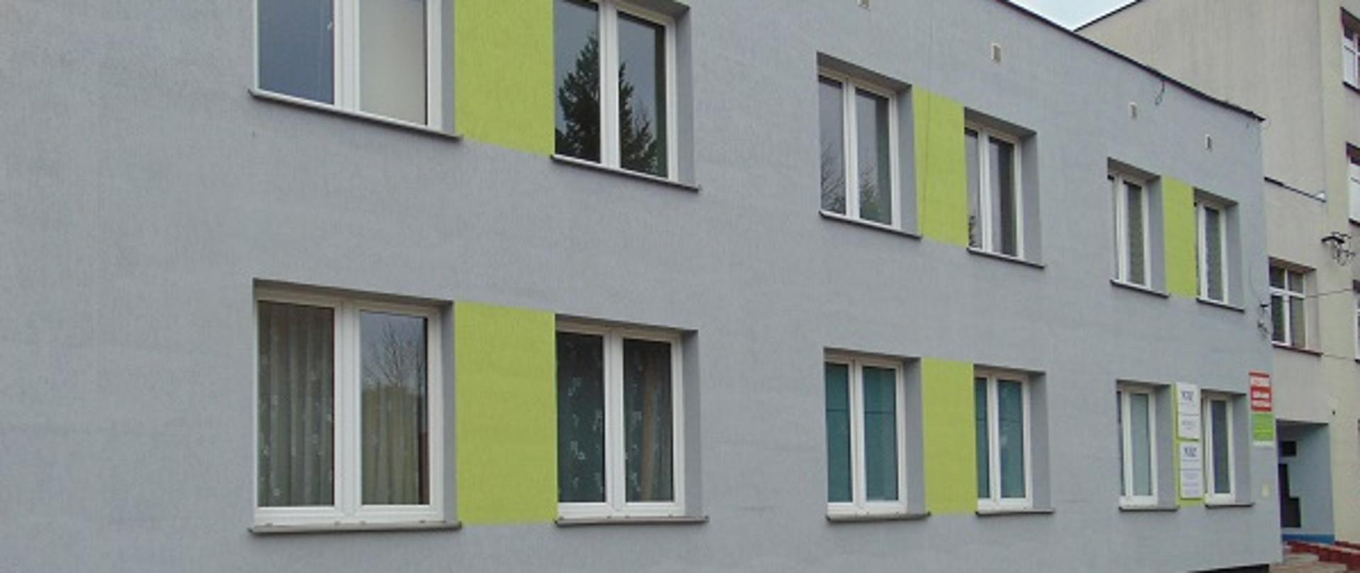 Fragment ściany budynku internatu, po prawej stronie wejście, przed budynkiem plac wybrukowany kostką