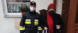 Na zdjęciu na tle wejścia do domu seniora strażak z OSP w Gulbinach wraz z seniorem