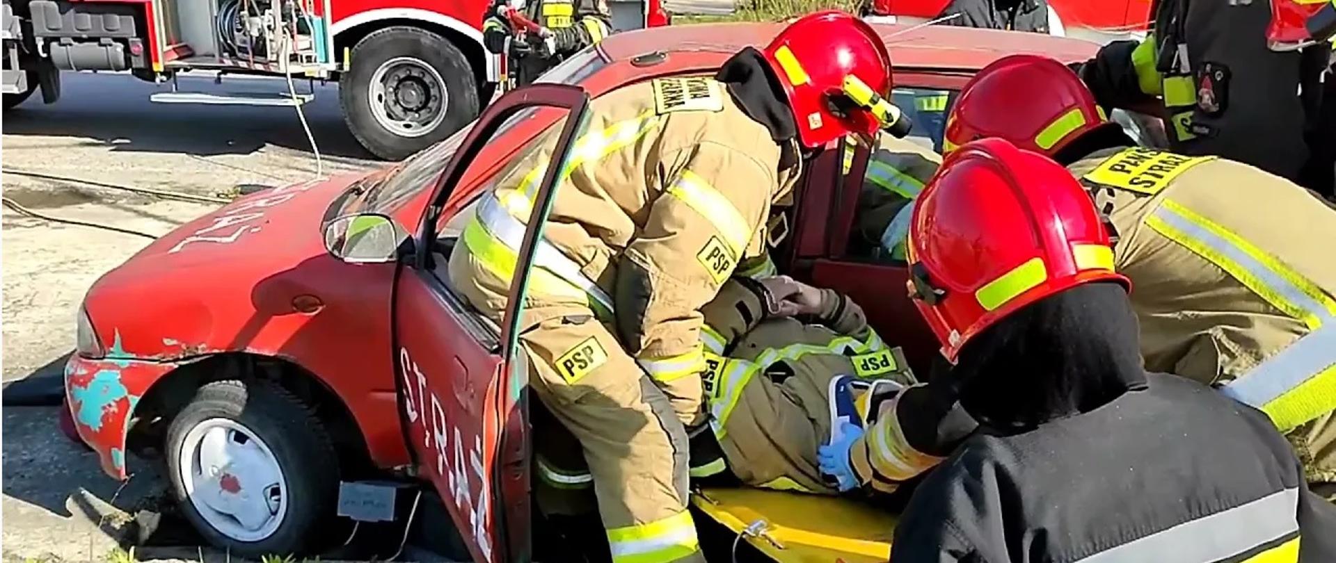 Strażacy podczas ćwiczeń z wydobywania poszkodowanego z pojazdu