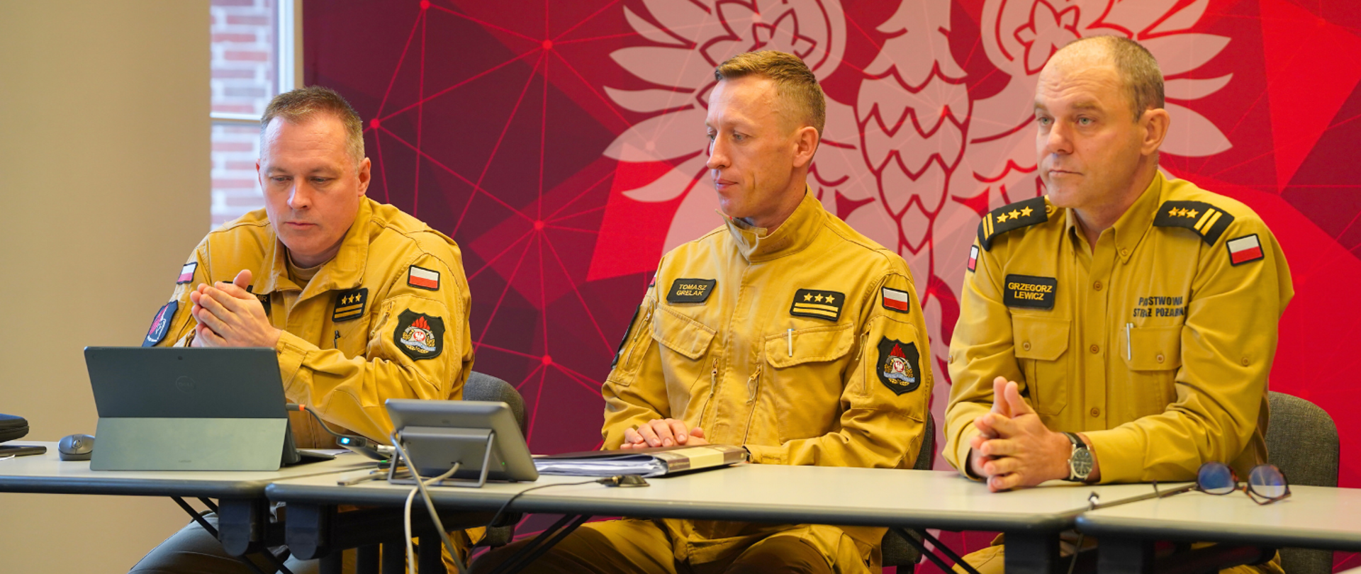 Panowie Komendanci oraz Naczelnik wydziału rozpoczynają wideokonferencję, zajmując na środku sali miejsca za stołem