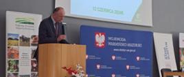 Warmińsko - Mazurski Wojewódzki Inspektor Jakości Handlowej Artykułów Rolno - Spożywczych Ryszard Piórkowski przy mównicy w auli Urzędu Wojewódzkiego rozpoczynający konferencję