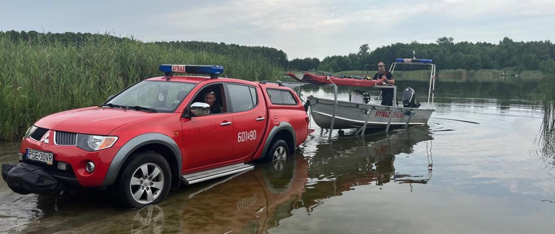 Na zdjęciu samochód strażacki z przyczepą do przewozu łodzi podczas wodowania łodzi
