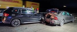 Dwa samochody osobowe, jeden wjechał w tył drugiego, jeden ma zniszczony przód, w drugim zniszczony tył i podniesiona klapa bagażnika.