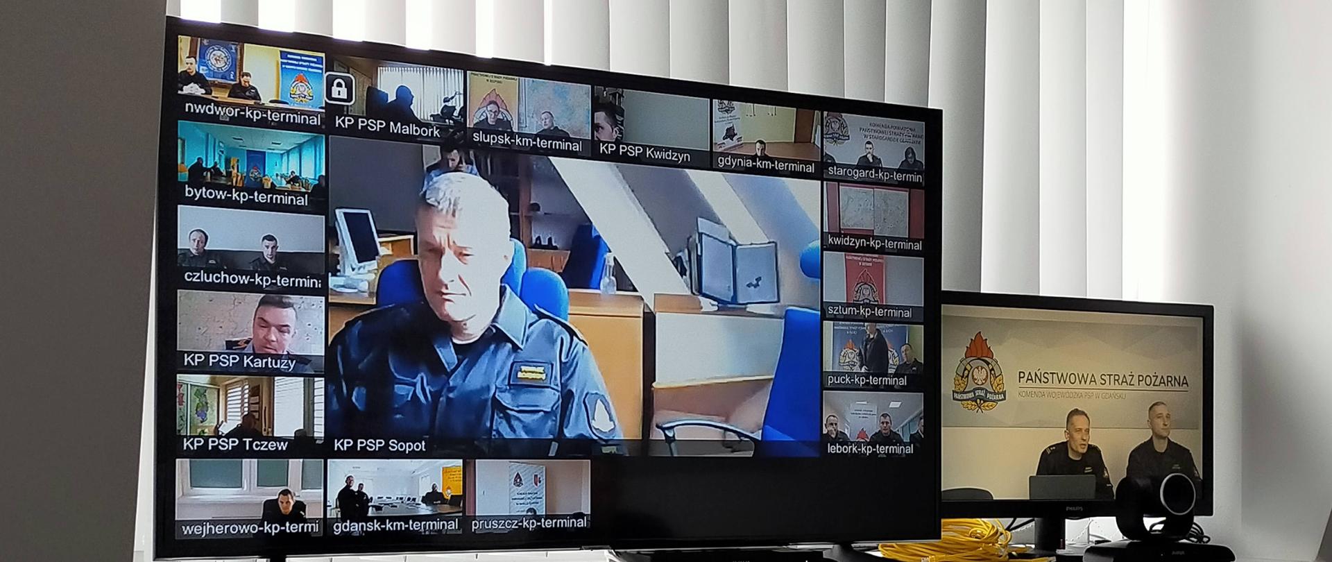 Monitor z dyżurnymi operacyjnymi z komend miejskich/powiatowych PSP uczestniczących w szkoleniu.