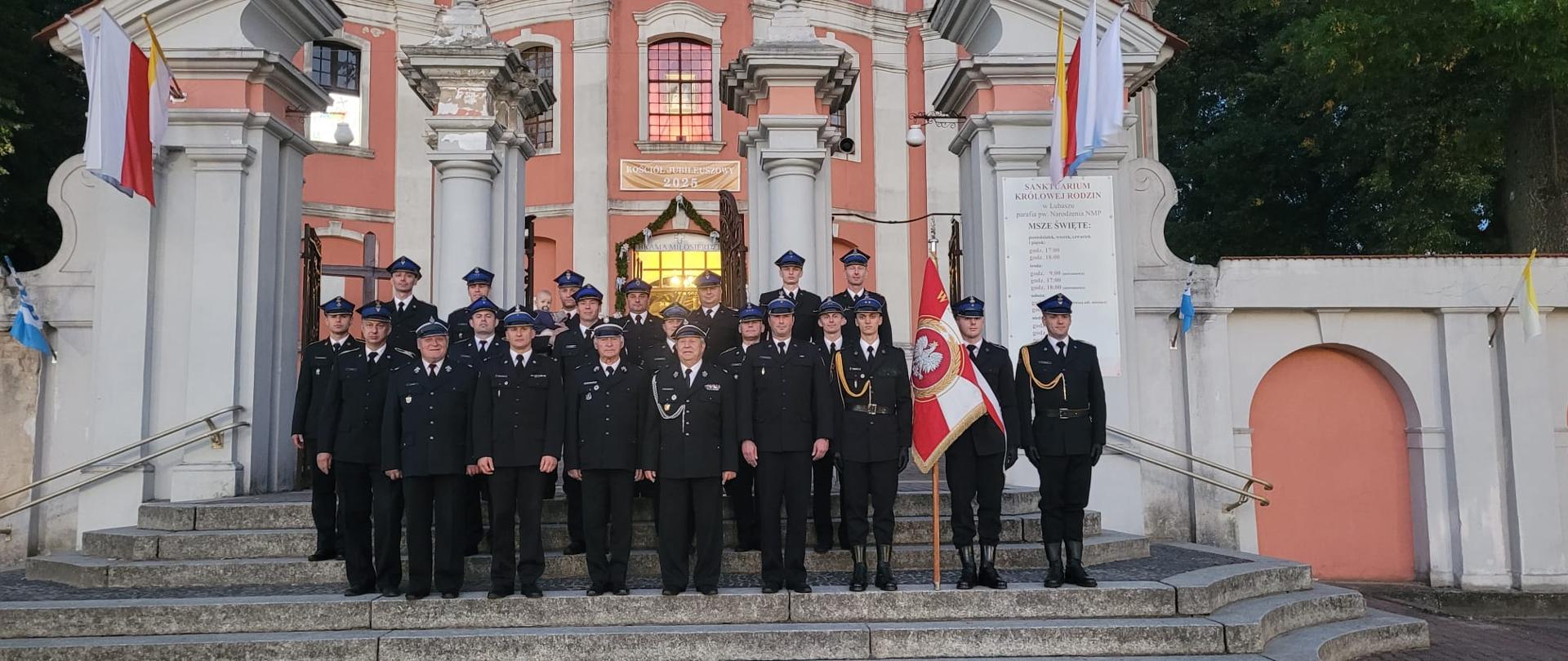 1. Wspólne zdjęcie strażaków PSP i OSP na schodach przed kościołem Parafii pod wyzwaniem Narodzenia Najświętszej Maryi Panny w Lubaszu.
