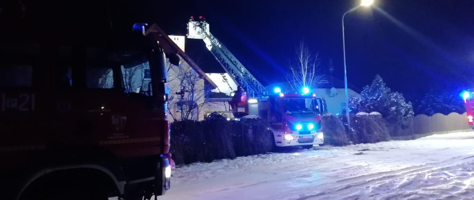 Na zdjęciu widać wozy gaśnicze w czasie prowadzonej akcji z wykorzystaniem mechanicznej drabiny strażackiej 