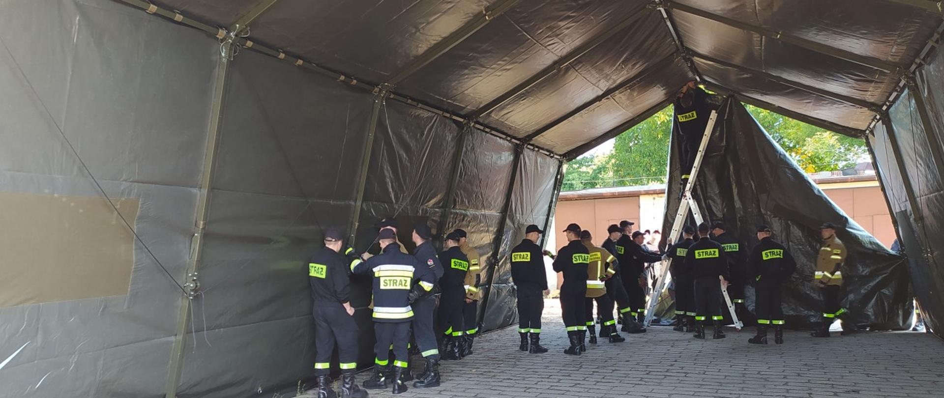 Ćwiczenia związane z przeciwdziałaniem skutkom pandemii COVID-19 - Kadeci podczas budowy tylnej ściany namiotu