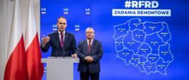 Minister infrastruktury Andrzej Adamczyk oraz wiceminister infrastruktury Rafał Weber podczas konferencji, której tematem były zadania remontowe przeznaczone do dofinansowania w ramach Rządowego Funduszu Rozwoju Dróg na 2023 rok.