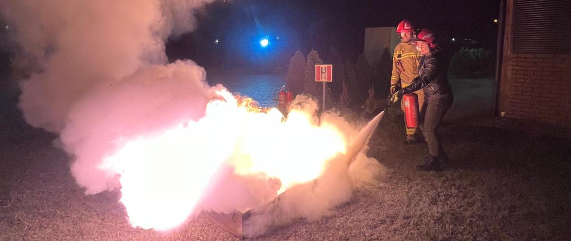 Gaszenie palącej się cieczy gaśnicą.