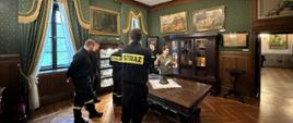 Sala muzealna w której znajduje się grupa strażaków wraz z przewodniczką