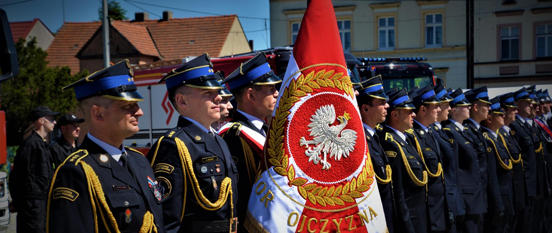 Pododdział pożarniczy stoi podczas uroczystości.