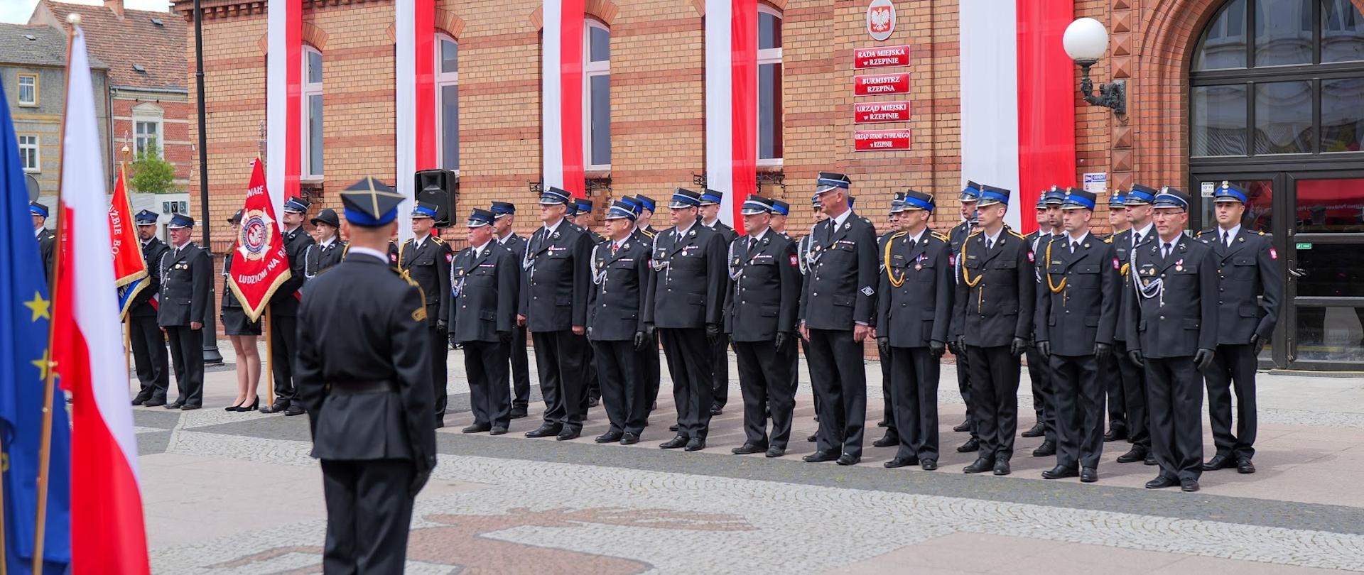 Pododdział strażaków w umundurowaniu wyjściowym. Widok z od przodu.
