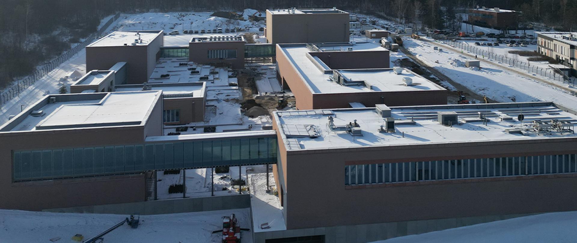 Widok z lotu ptaka na kompleks budynków w zimowej scenerii.