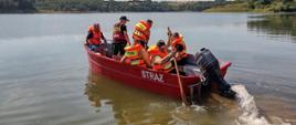 Strażacy w łodzi ratunkowej wypływają z nabrzeża zbiornika wodnego "Wióry"