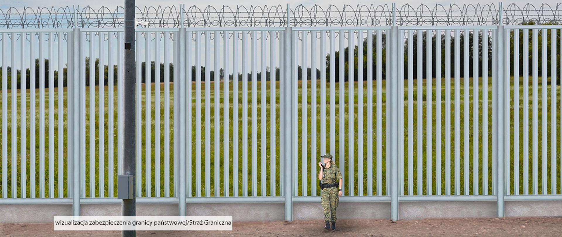 Mur, przy murze stoi funkcjonariusz.