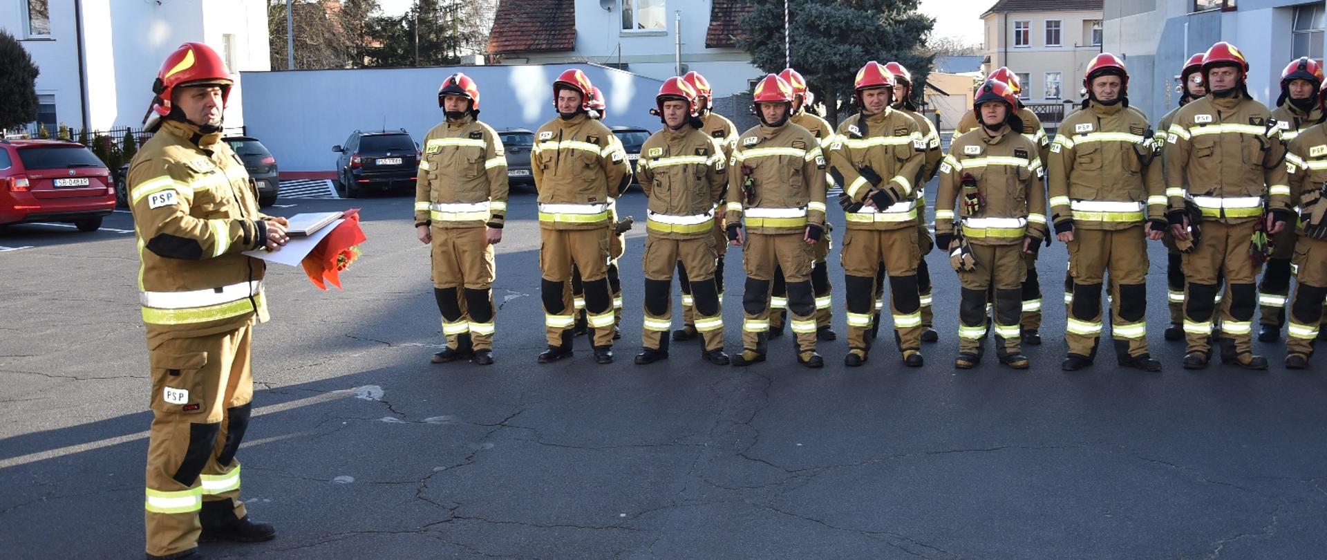 Strażak wygłasza przemówienie na koniec służby.