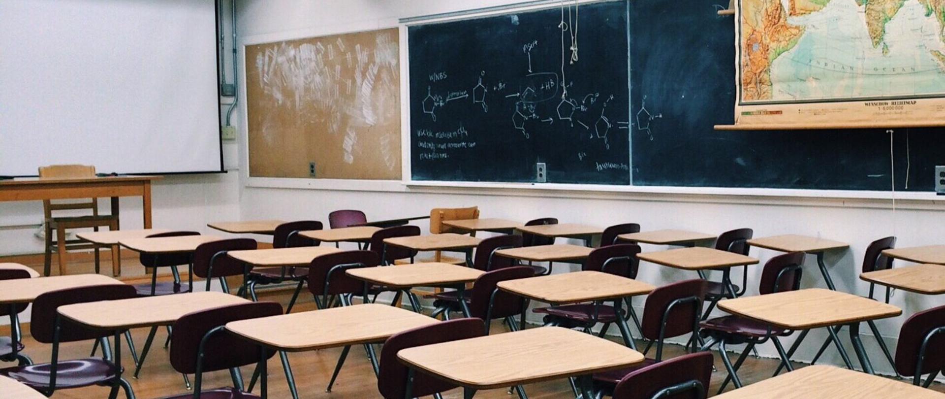 Klasa szkolna z ławkami i mapą świata na ścianie