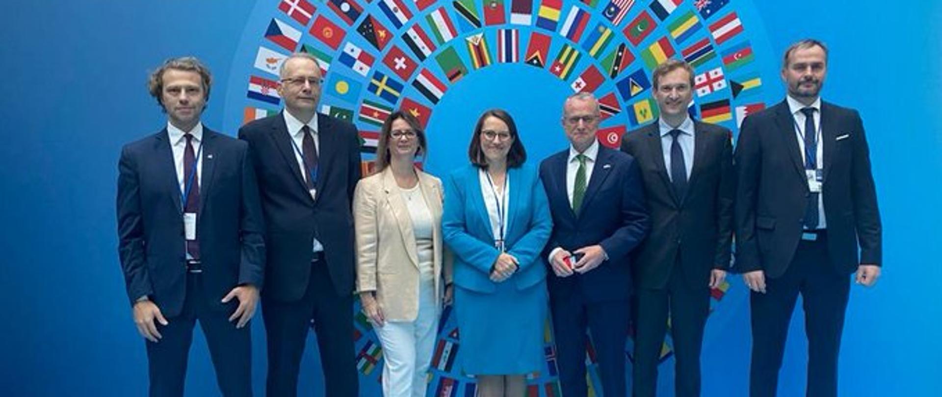 Delegacja Ministerstwa Finansów na sesji MFW i BŚ w Waszyngtonie na tle fla