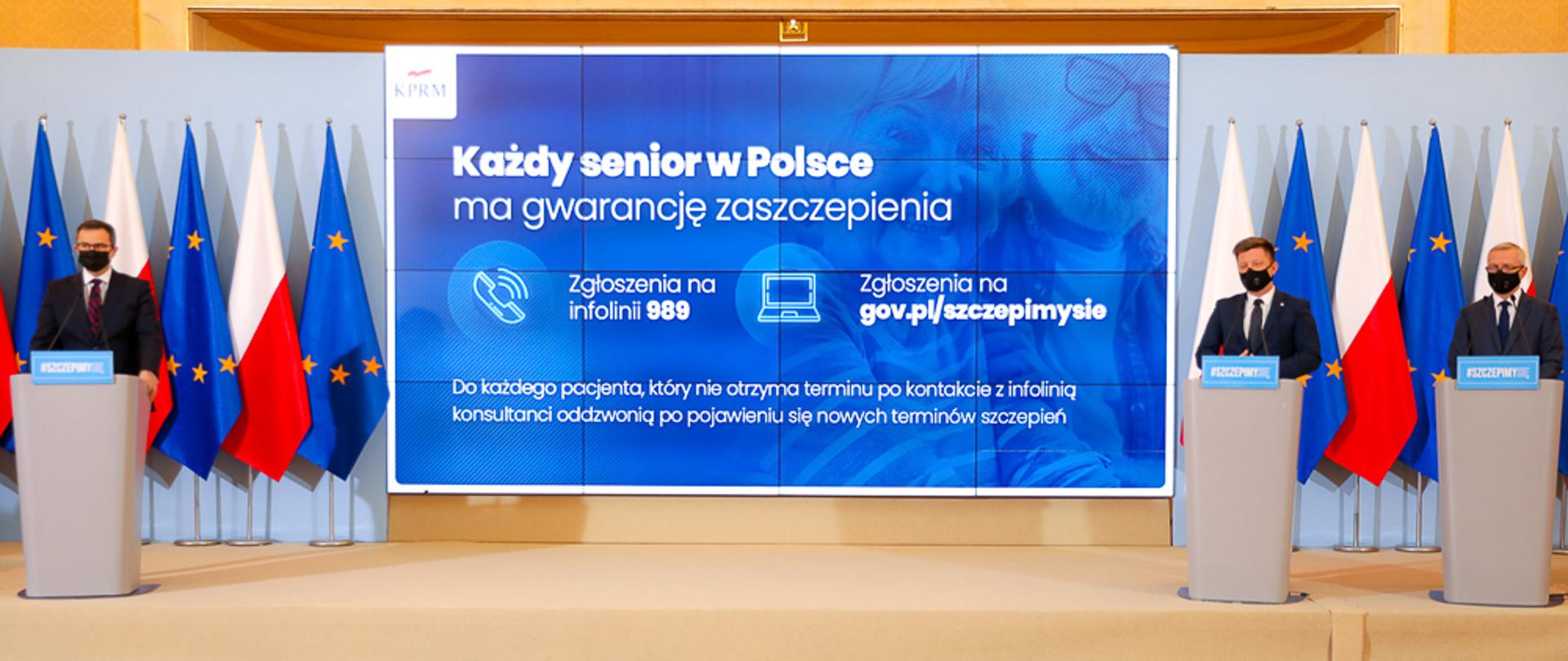 Konferencja prasowa z udziałem Szefa KPRM Michała Dworczyka oraz sekretarza stanu Marka Zagórskiego. W tle ekran z napisem: "każde senior w Polsce ma gwarancję zaszczepienia"