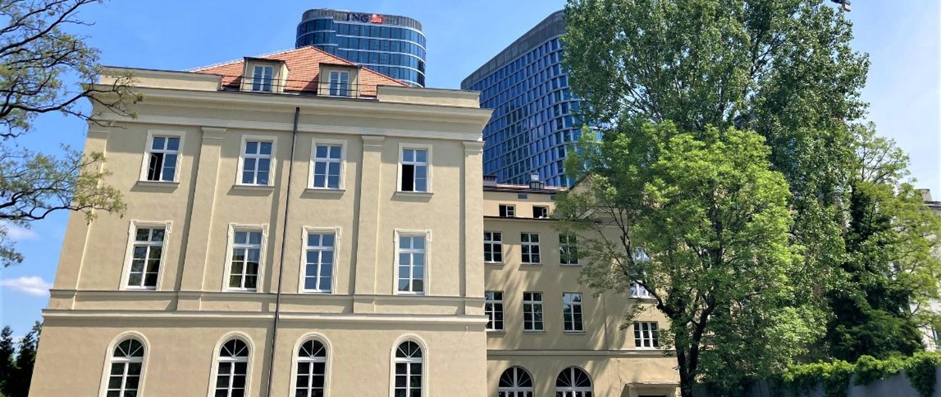 Budynek POSM I stopnia im. S. Moniuszki na tle nowoczesnych szklanych biurowców