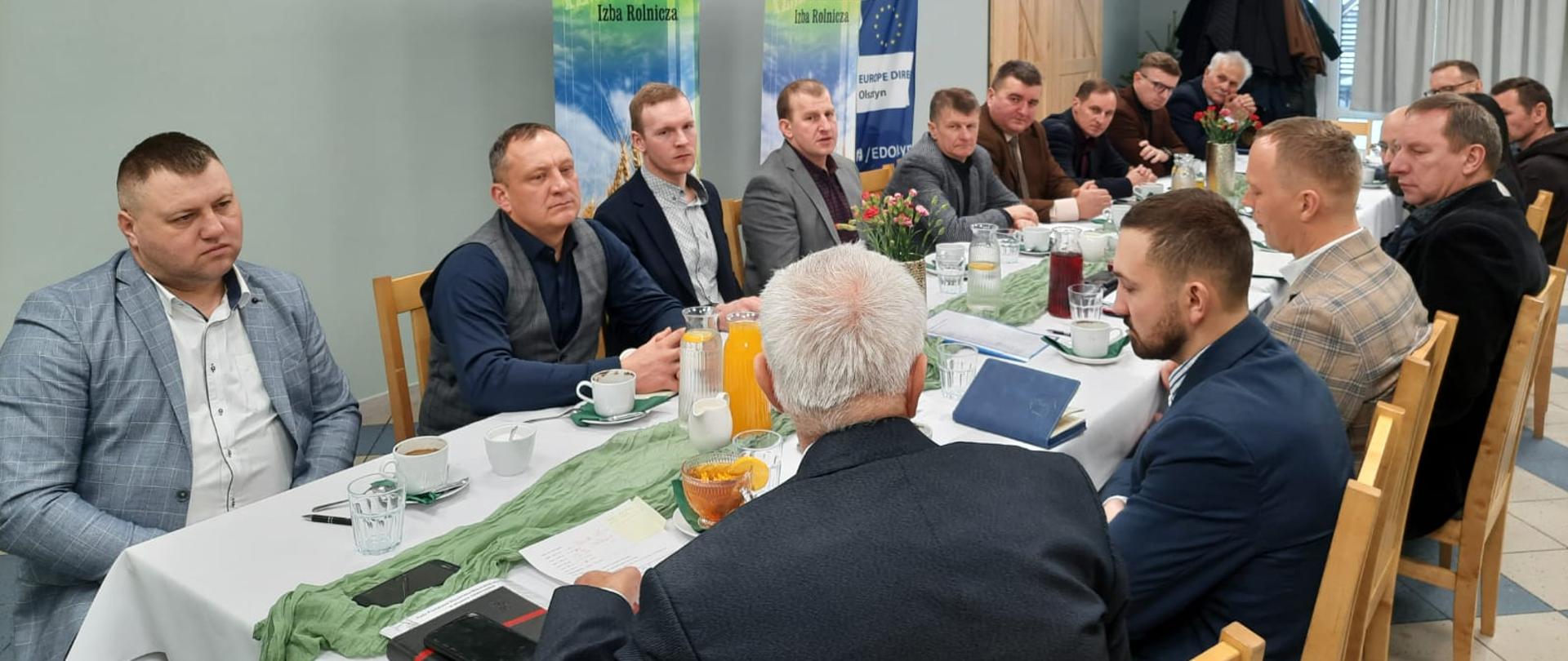 Grupa osób siedzących przy stole oraz słuchających prelekcji na spotkaniu Rady Powiatowej