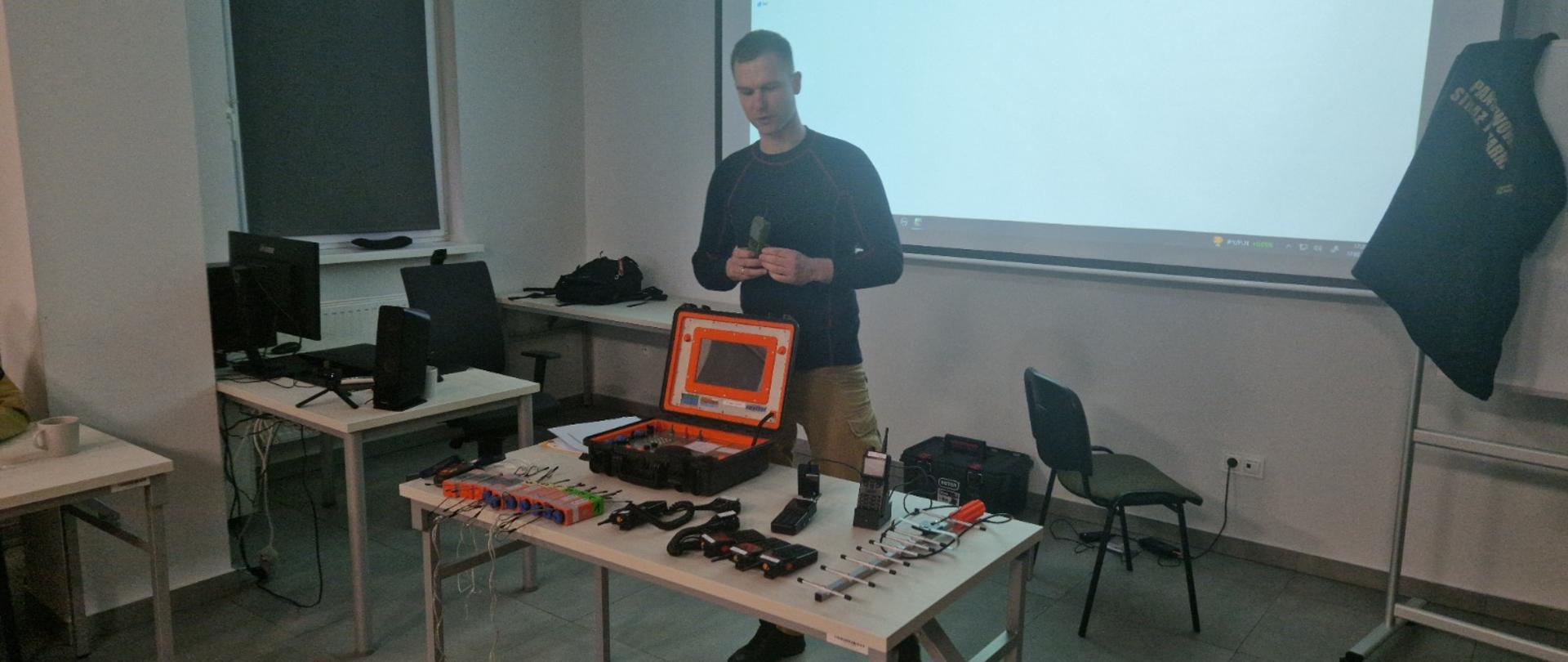 Zdjęcie przedstawia strażaka prezentującego sprzęt.