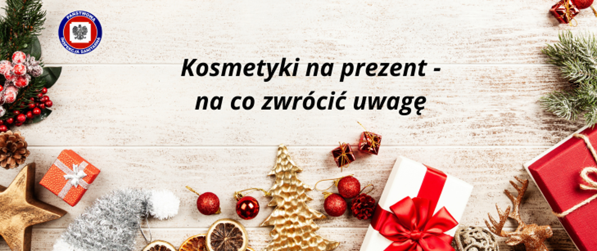 Na drewnianej podłodze wokół rozsypane są różne ozdoby świąteczne i prezenty, na środku ciemny napis Kosmetyki na prezent - na co zwrócić uwagę, w lewym górnym rogu logo Państwowej Inspekcji Sanitarnej.