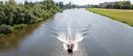 Strażacy Państwowej Straży Pożarnej podczas ćwiczeń na Odrze w Opolu. Strażacy w łodzi udają się do miejsca ćwiczeń. Zdjęcie wykonane przy użyciu bezzałogowego statku powietrznego.