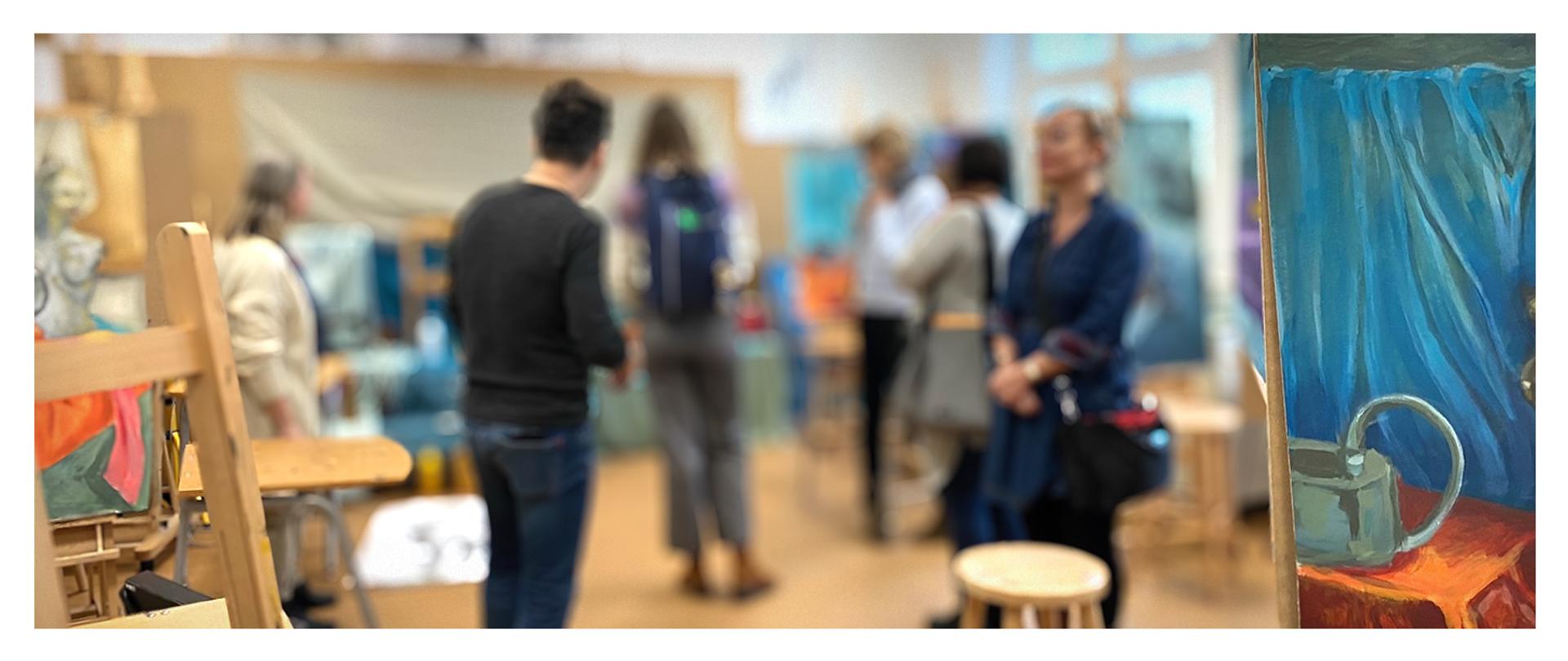 grupa osób w pracowni malarskiej, na pierwszym planie sztalugi, w tle martwa natura