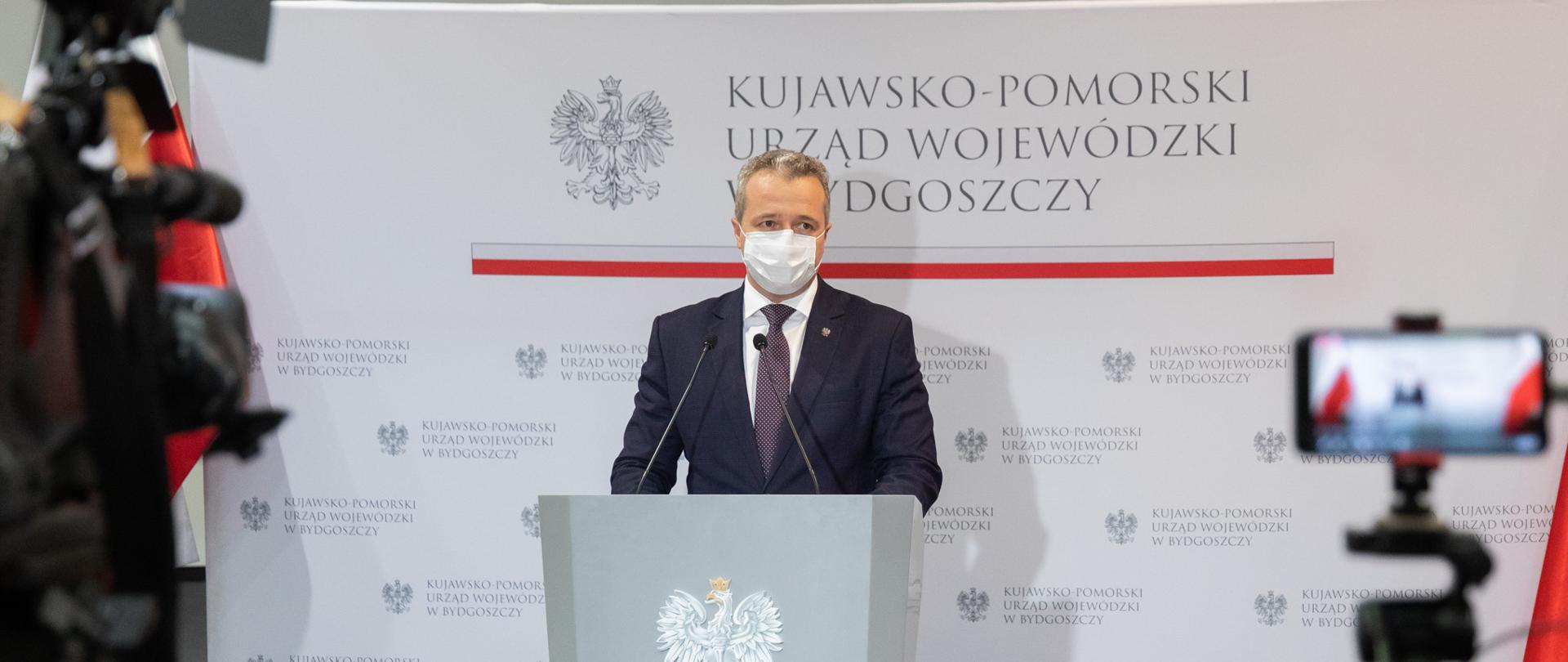 Jeden mężczyzna stojący przed mównicą i wypowiadający się