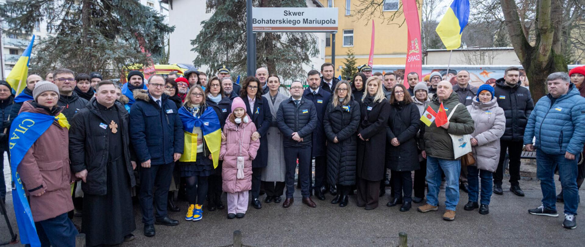 kilkadziesiąt osób m.in. z flagami ukraińskimi stoi na skwerze bohaterskiego Mariupola