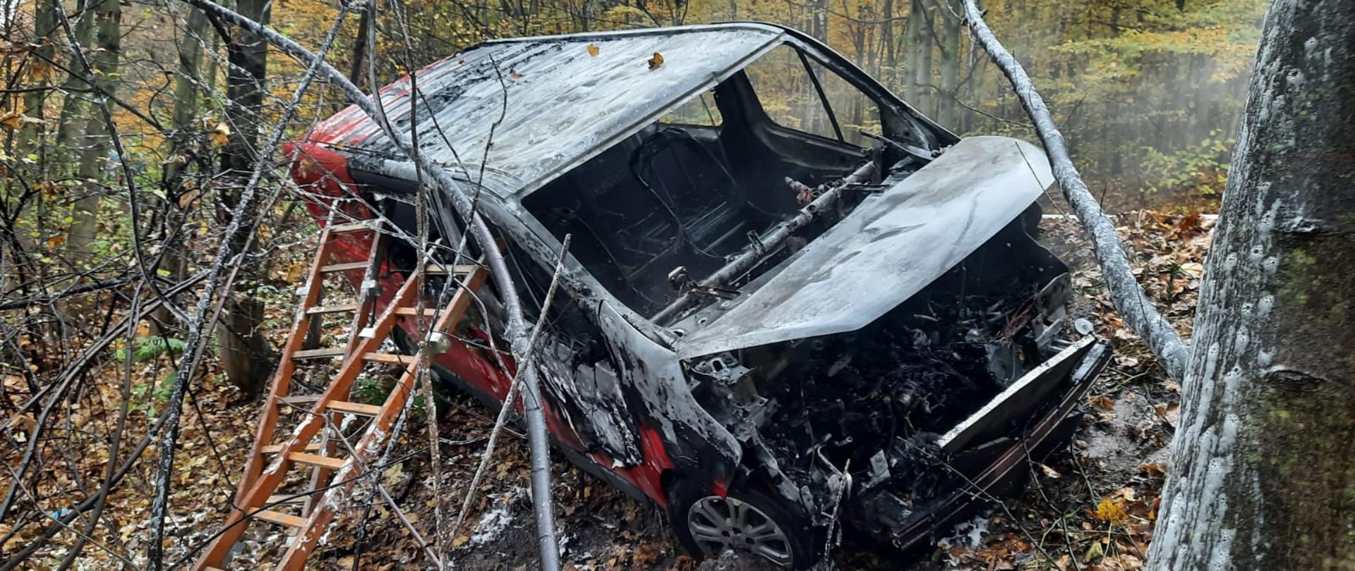 Zdjęcie przedstawia spalony samochód typu bus
