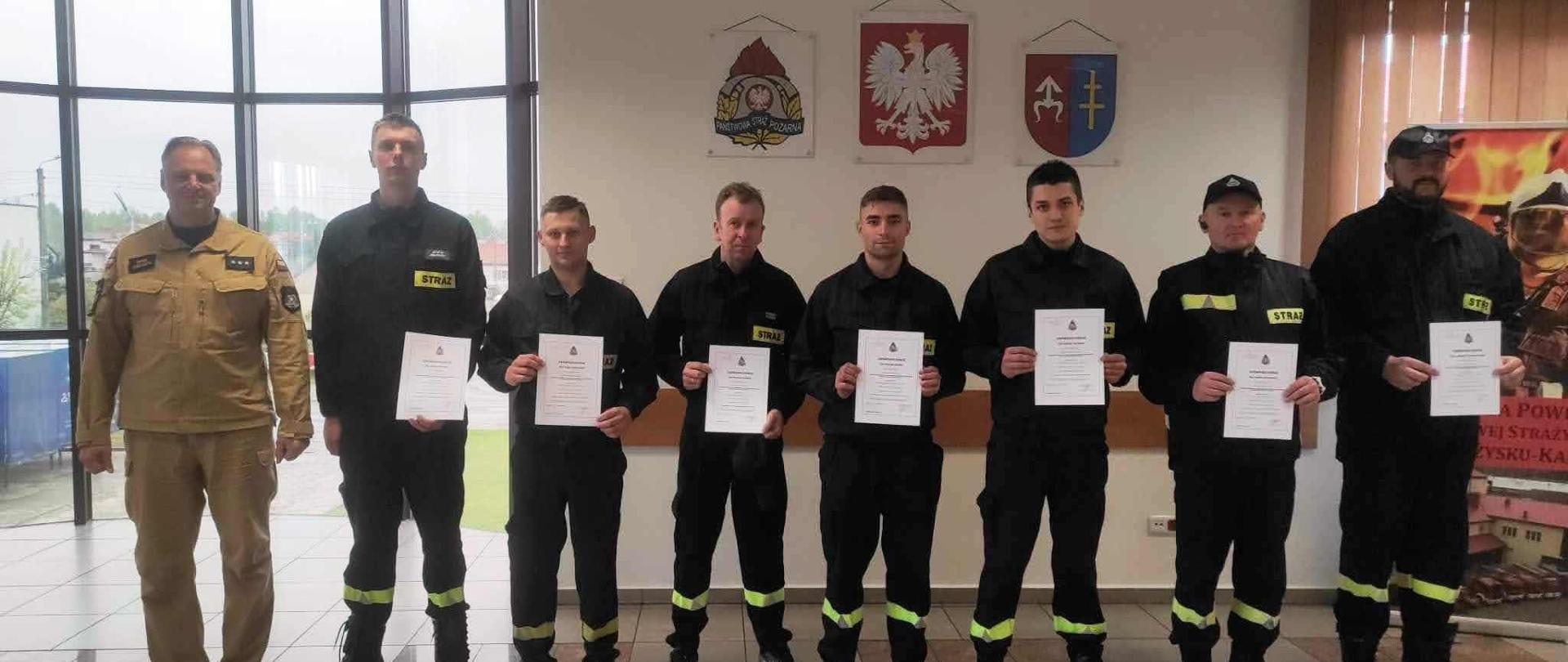 Grupowe zdjęcie osób, które ukończyły szkolenie Kierowców Konserwatorów Sprzętu Ratowniczego na auli KP PSP w Skarżysku-Kam.