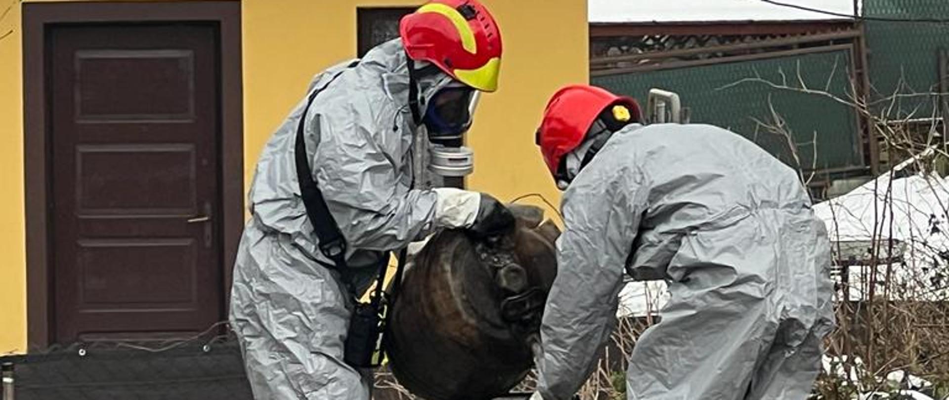 Strażacy przelewają substancję z uszkodzonego pojemnika