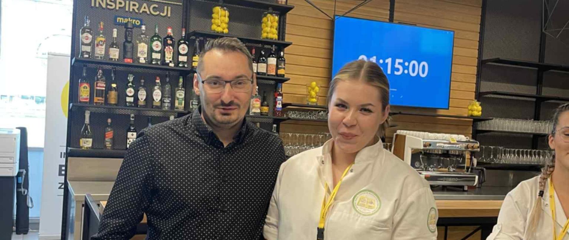 Mężczyzna i uczestniczka pozują w przestrzeni konkursowej kuchni