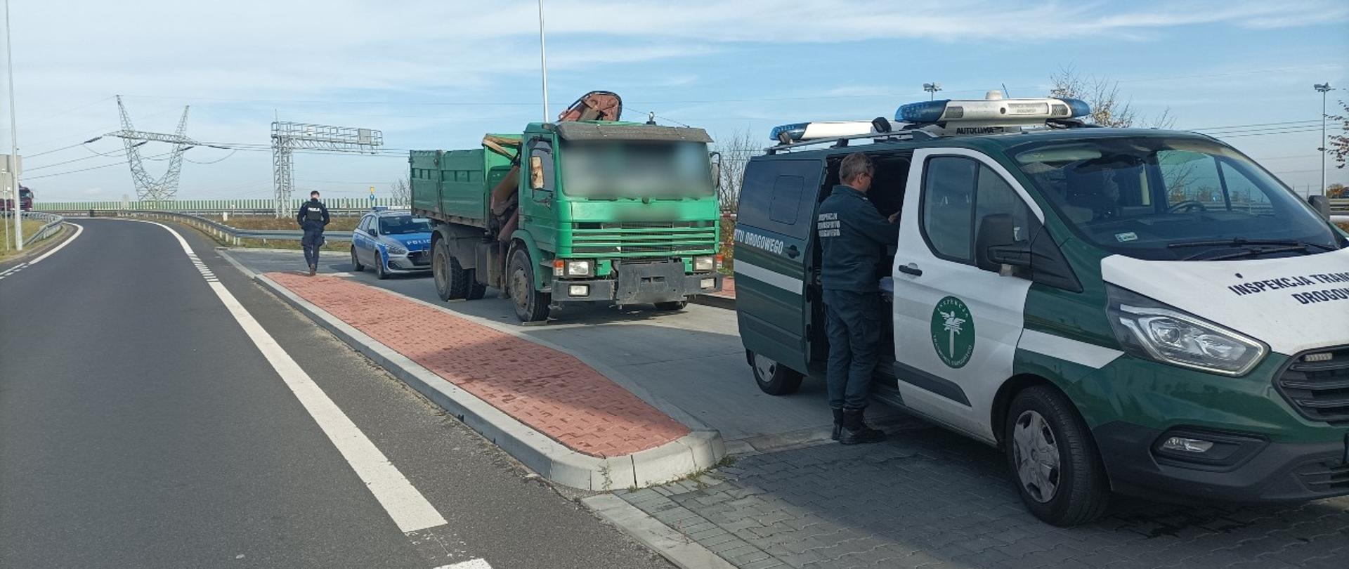 Wywrotka zatrzymana do kontroli przez patrol z Głównego Inspektoratu Transportu Drogowego w pobliżu Poznania. Na miejscu są też wezwani funkcjonariusze Policji.