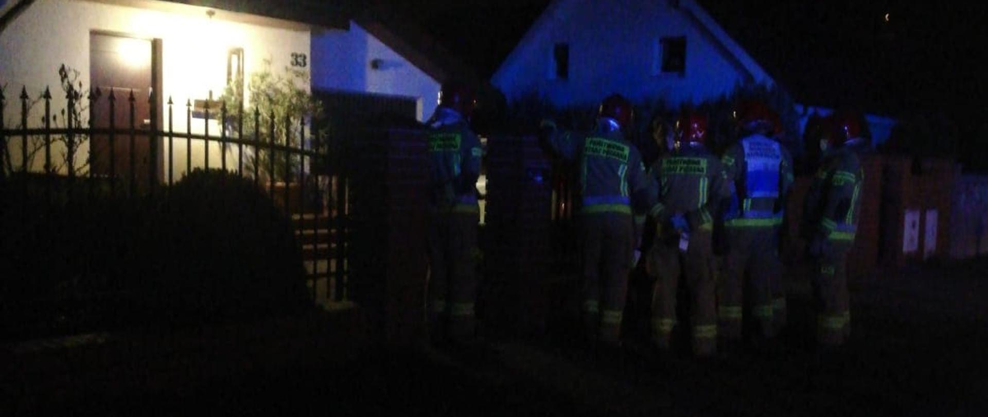 Na zdjęciu strażacy przed posesja podczas działań związanych z podejrzeniem zatrucia tlenkiem węgla