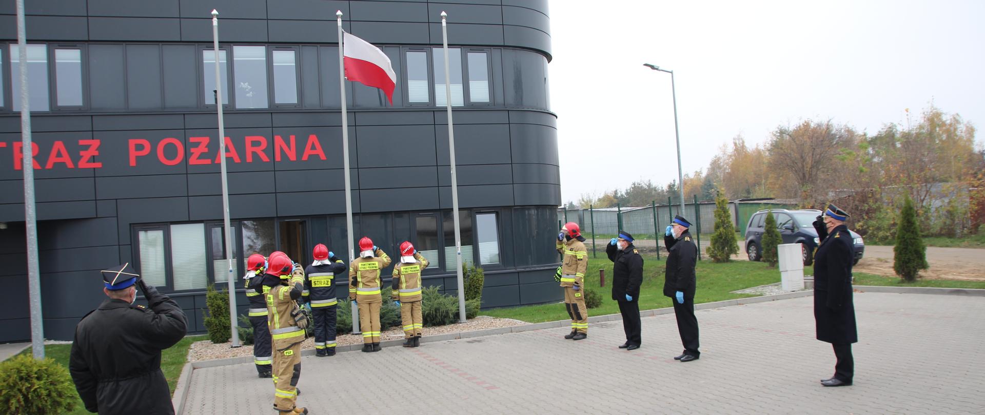 zdjęcie przedstawia funkcjonariuszy Komendy Powiatowej Państwowej Straży Pożarnej podczas przeprowadzania uroczystej zmiany służbowej 