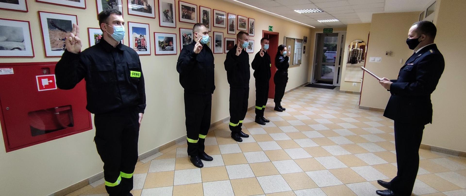 Pięciu strażaków z uniesioną prawą dłonią do ślubowania