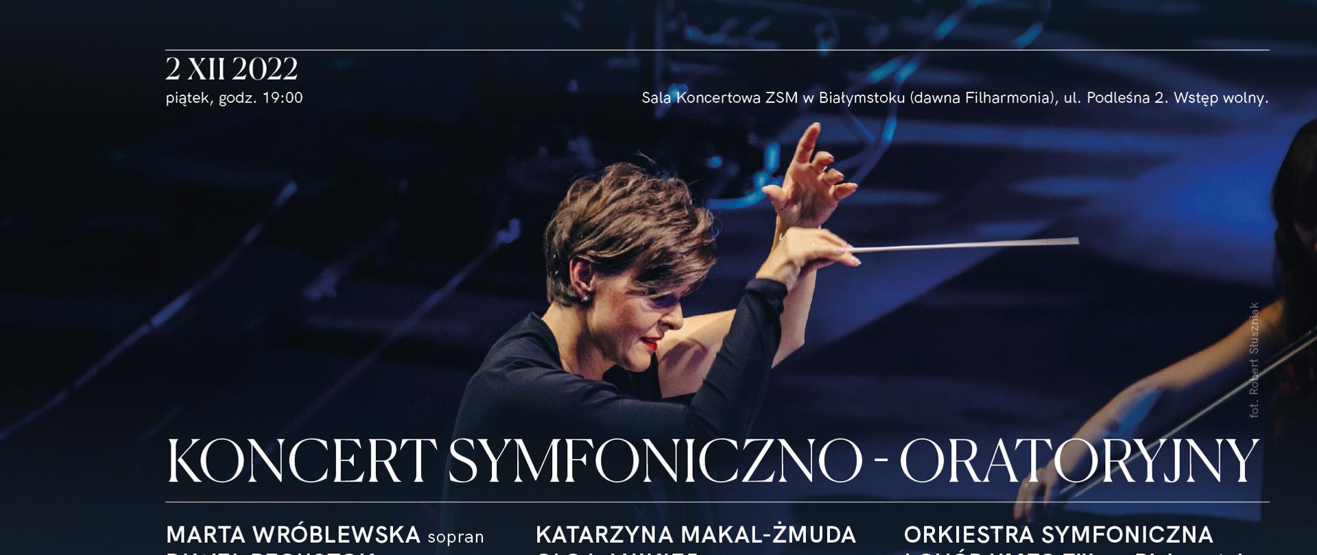 Plakat koncertowy w kolorze ciemnogranatowym. W środku sylwetka dyrygentki w wyraźnym geście uniesionych dłoni z batutą w ręku. Na dole napis informacyjny o szczegółach koncertu.