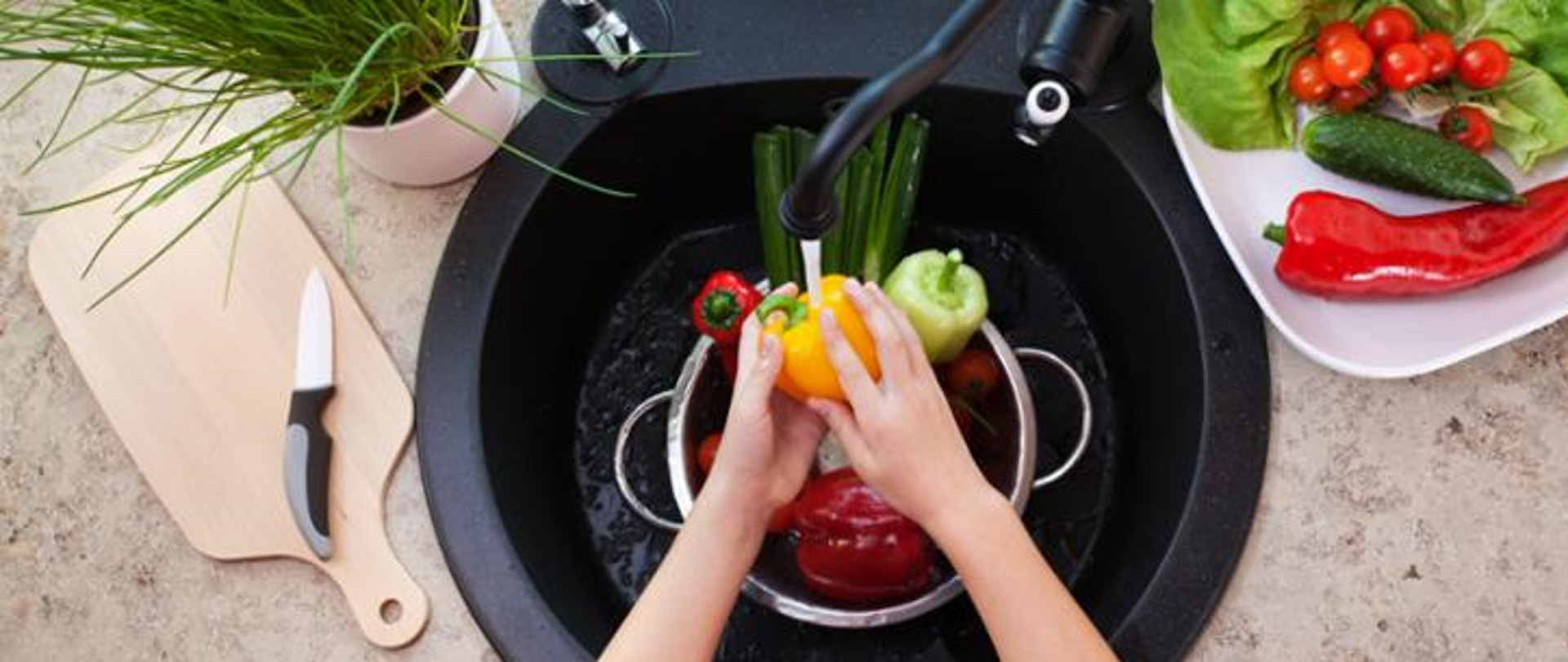 w centralnej części grafiki widzimy osobę, która myje warzywa pod bieżącą wodą